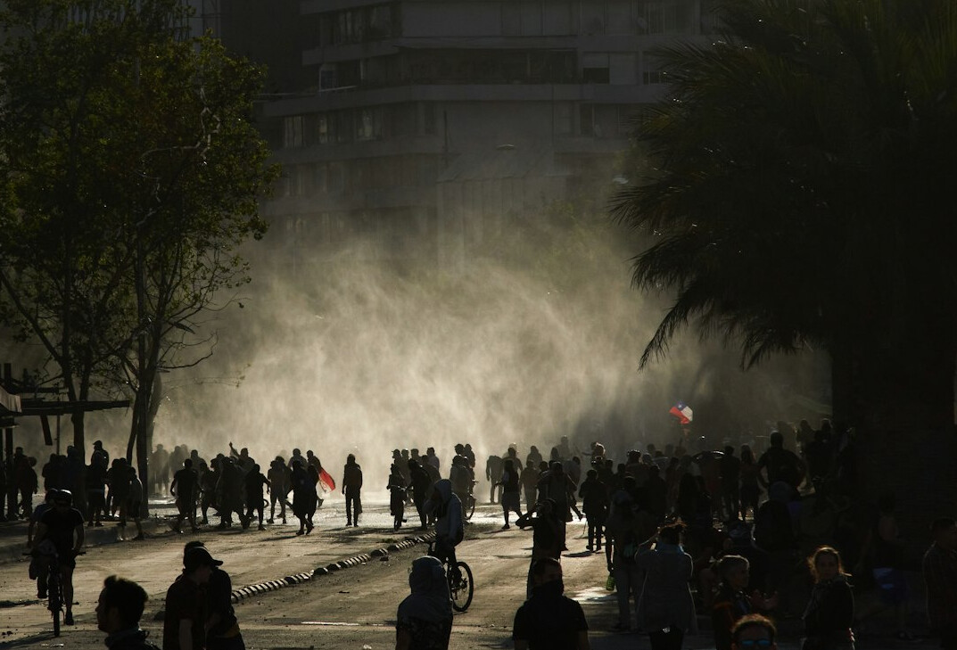 People waiting in line on a busy city street in Chile